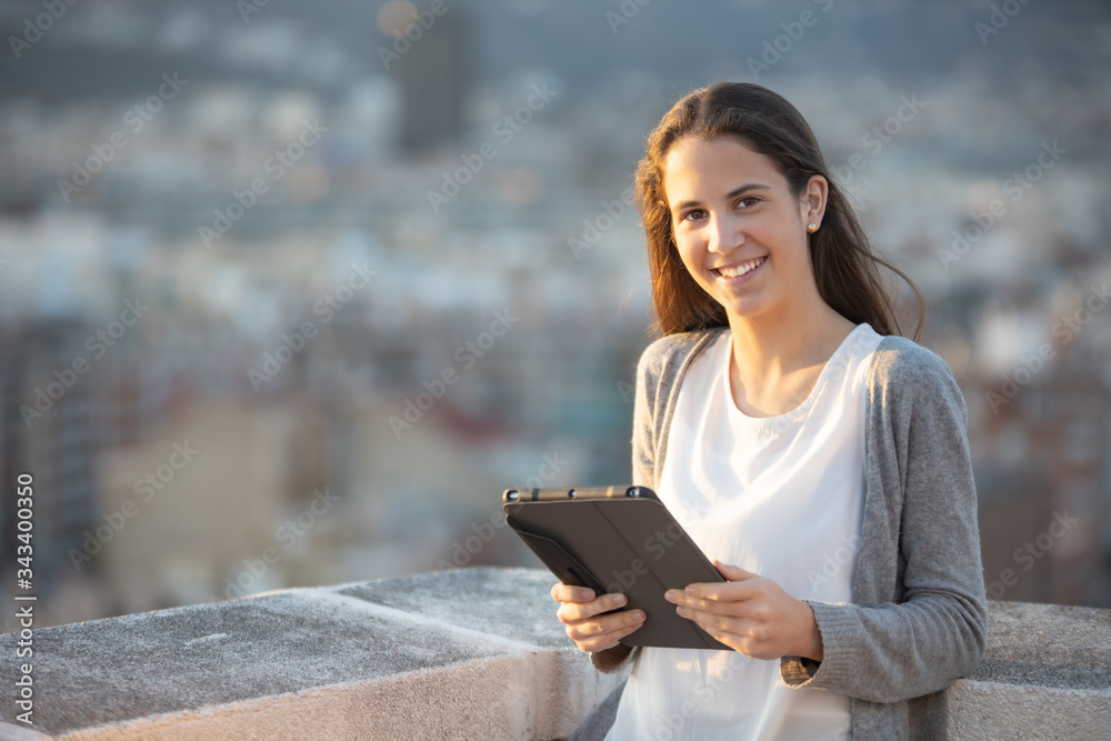Smiling woman looking at the camera using a tablet Smiling woman looking at the camera using a tablet