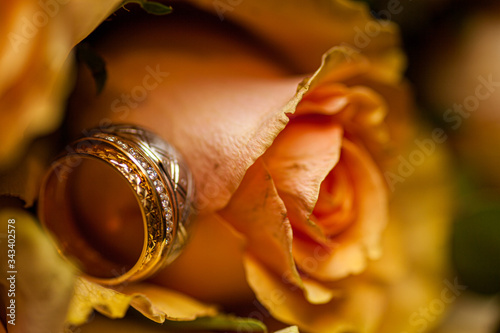 Close-up of two Wedding rings and the wedding bouquet of pink roses on a weddings day 