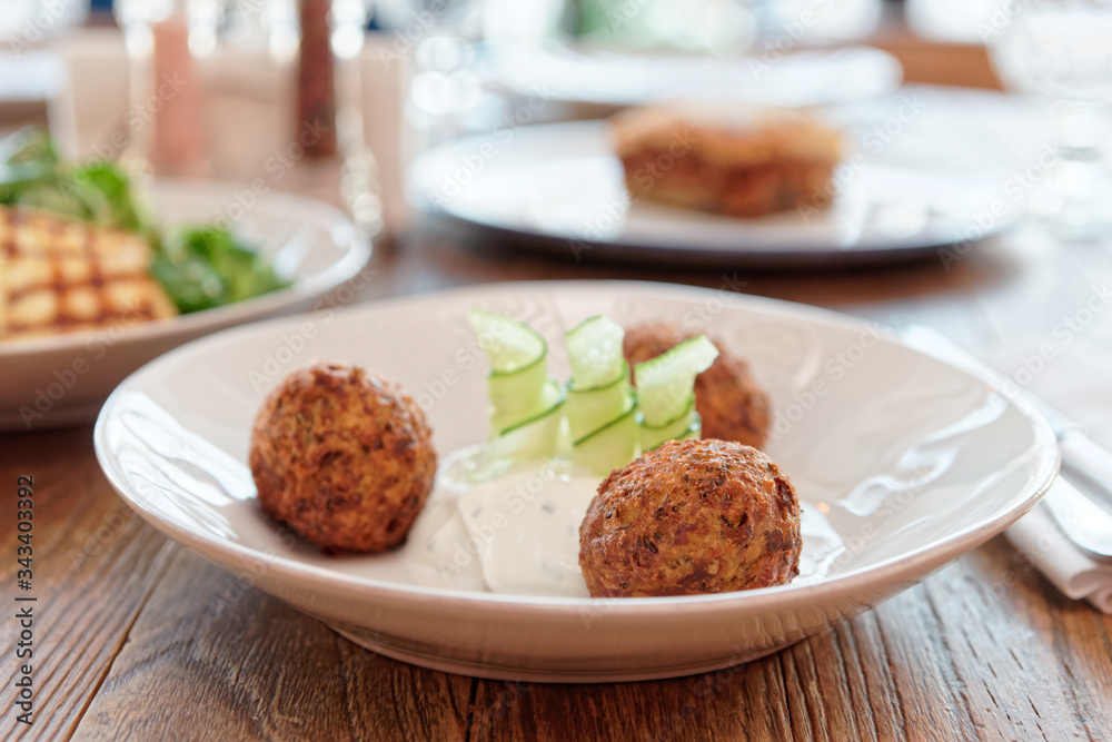 Zucchini croquettes and other dishes on restaurant table