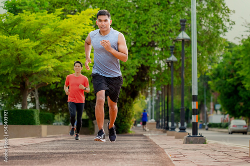 Portrait of handsome man running in the park in early morning. Healthy concept