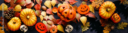 Pumpkins with Halloween decorations on dark background photo