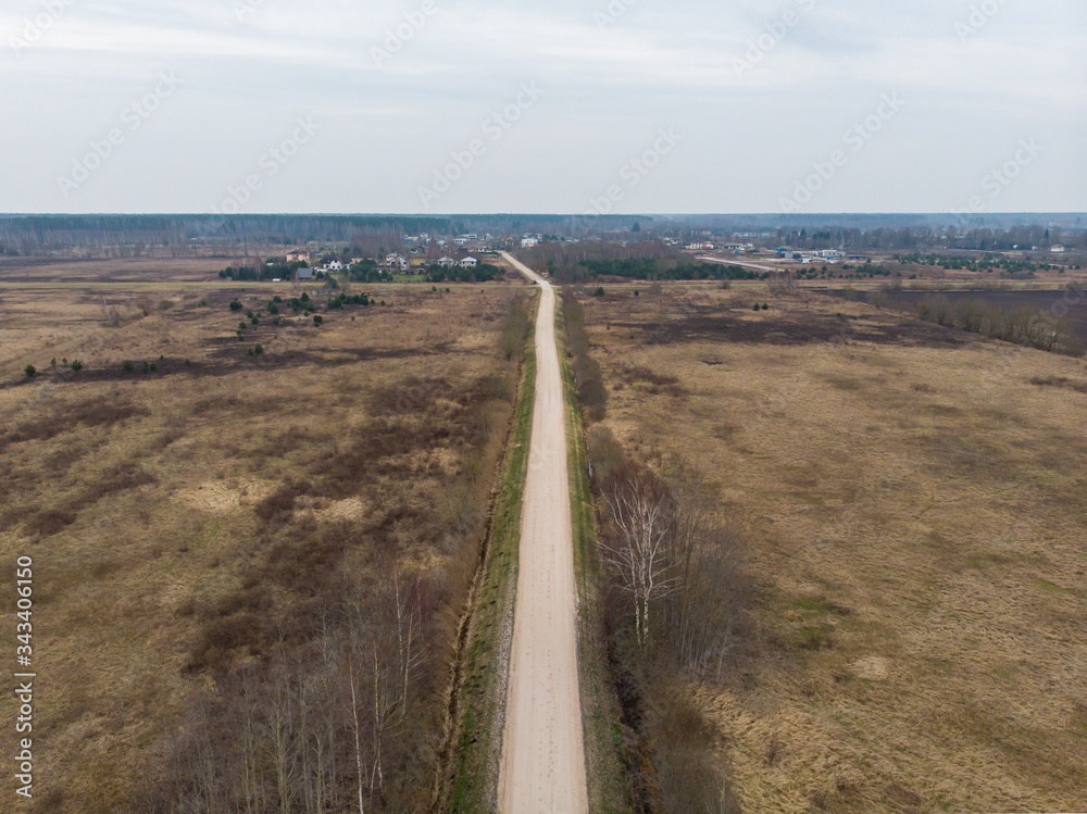Areal view of old countryside road near agriculture fields.