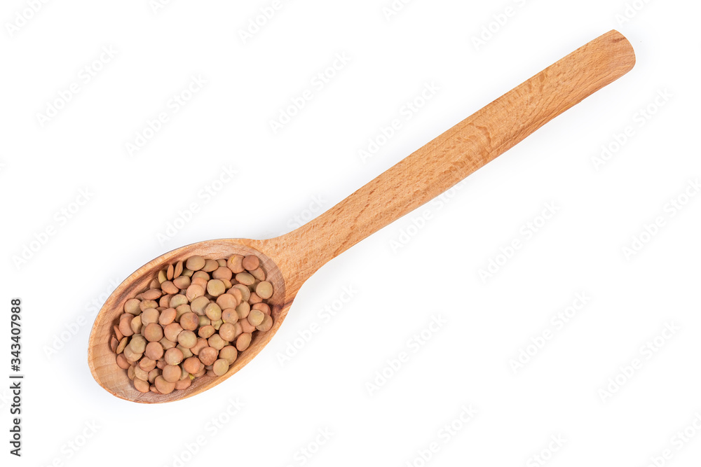 Raw brown lentil in wooden spoon on a white background Raw brown lentil in wooden spoon on a white background