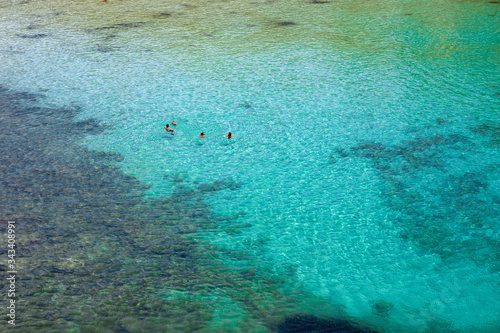 MENORCA  SPAIN - JULY 14  2015  Bathers refresh themselves in the fresh and transparent waters of a bay on the island of Menorca in Spain.