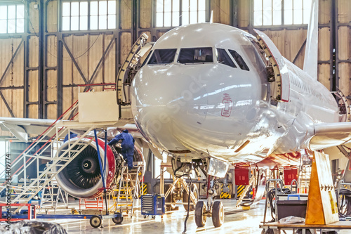 Aviation hangar and repairable passenger aircraft. Work mechanics on maintenance parts.