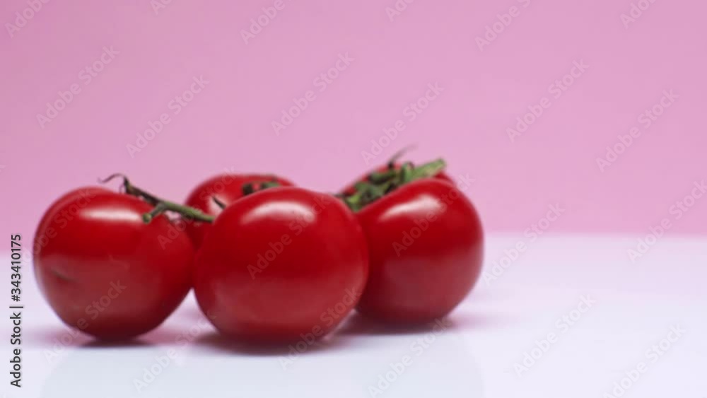 Fresh tomato juice and tomatoes on the background. A glass of freshly squeezed tomato juice. Closeup male hand takes a glass with tomato juice. Fresh tomato juice and tomatoes on the background. A glass of freshly squeezed tomato juice. Closeup male hand takes a glass with tomato juice.