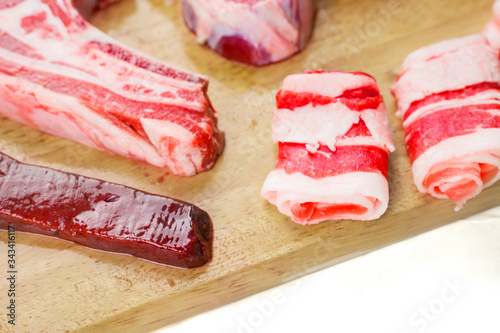 Various sliced raw meat on chopping board