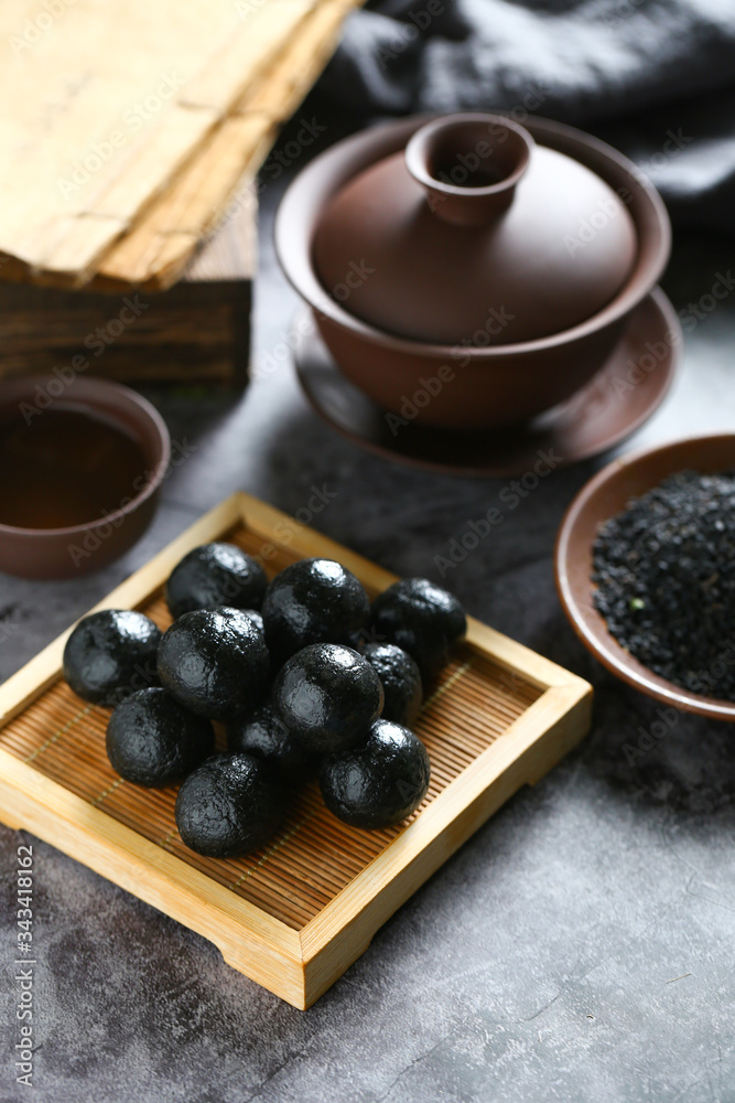 Chinese black sesame ball on bamboo plate with tea Chinese black sesame ball on bamboo plate with tea