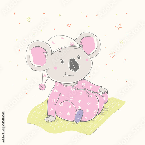 Lovely cute koala is sitting on the grass. Beautiful koala girl dressed in pink pajamas with hat.