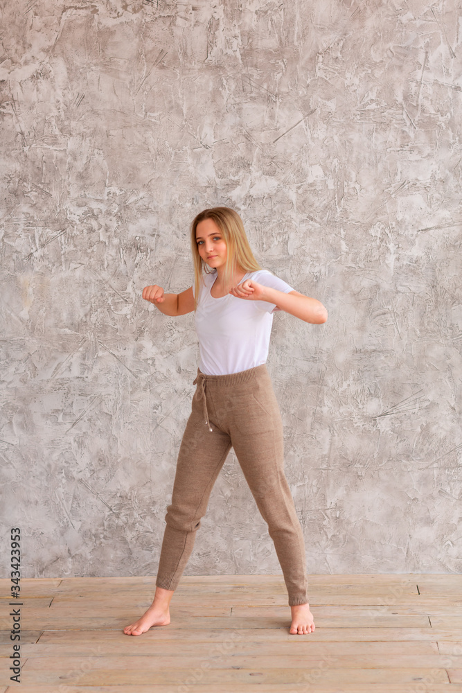 Tennage girl doing fitness gymnastics at home. Gymnastics exercises video tutorial. Children's activity in quarantine during coronavirus pandemic concept Tennage girl doing fitness gymnastics at home. Gymnastics exercises video tutorial. Children's activity in quarantine during coronavirus pandemic concept
