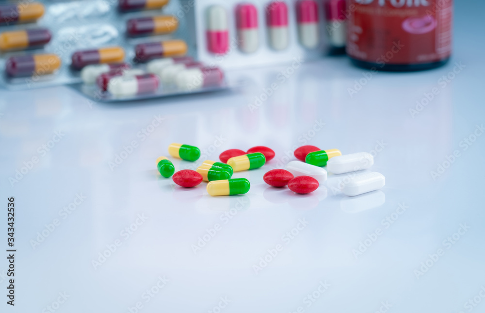Colorful tablets and capsule pills on blurred background of drug glass bottle and blister pack. Pharmacy drugstore products. Pharmaceutics and drug interactions concept. Pharmaceutical industry. Colorful tablets and capsule pills on blurred background of drug glass bottle and blister pack. Pharmacy drugstore products. Pharmaceutics and drug interactions concept. Pharmaceutical industry.