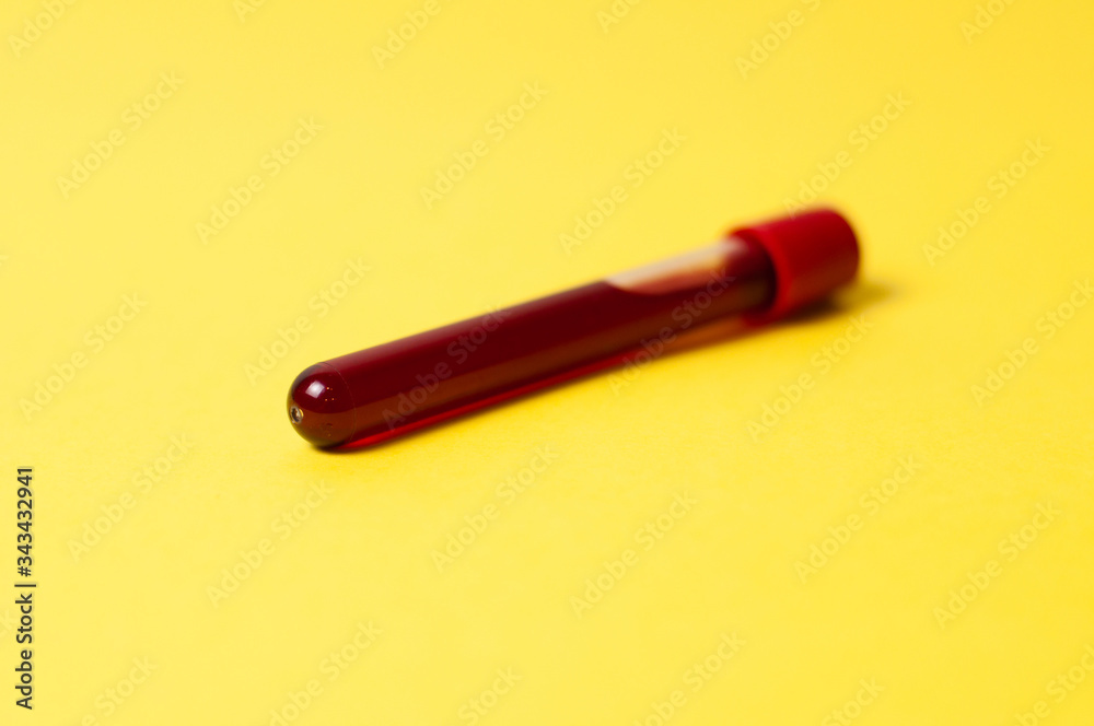 Test tube with blood isolate on a yellow background Test tube with blood isolate on a yellow background