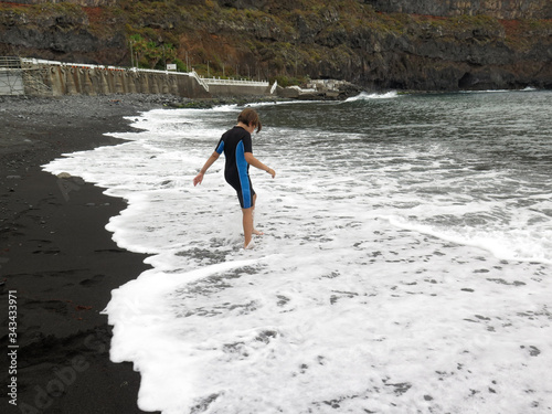 girl with neoprene playing in the beach