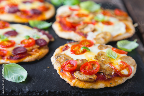 Homemade mini pizza with mushrooms, cheese and sausages