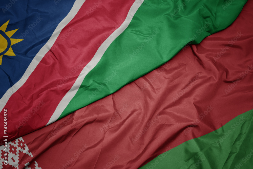 waving colorful flag of belarus and national flag of namibia.