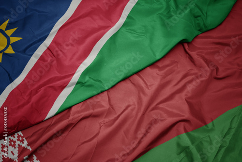 waving colorful flag of belarus and national flag of namibia.