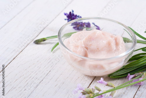 cosmetic cream and lavender flowers on white wood table background