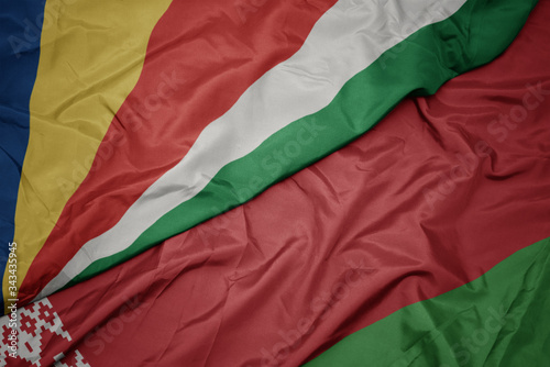 waving colorful flag of belarus and national flag of seychelles.