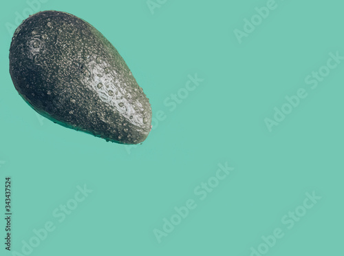 Avocado for the keto diet. Fresh avocado isolated on blue background closeup. Ripe fresh green avocado. Art green avocado. © Alexandra Mareeva