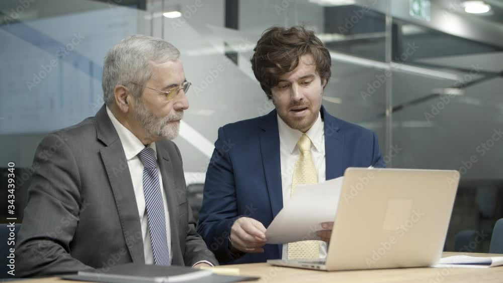 Young consultant explaining details of contract to senior client. Old man nodding and listening. Static camera. Medium shot video. Business and startup project concept Young consultant explaining details of contract to senior client. Old man nodding and listening. Static camera. Medium shot video. Business and startup project concept