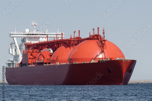 LNG TANKER - The beautiful red ship flows to the gas terminal unloading quay
