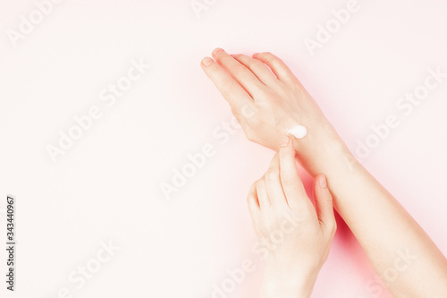 Woman moisturizing her hand with cosmetic cream  concept for feminine blog  social media  beauty concept