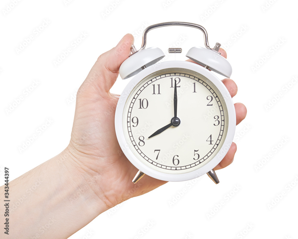 Hand with an alarm clock in a hand. Isolated on white background. Close up