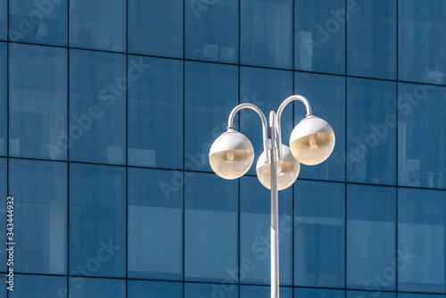 Architecture abstract background. Street light against glass curtain wall