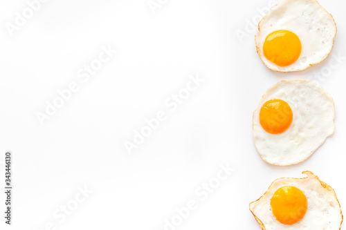 Fried eggs frame on white table top view copy space