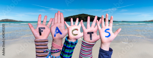 Children Hands Building Colorful English Word Facts. Ocean And Beach As Background