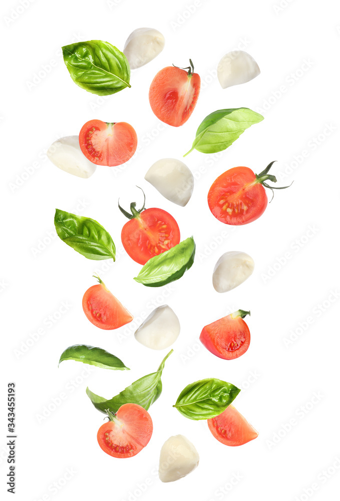 Mozzarella cheese balls, tomatoes and basil leaves falling on white background. Caprese salad Mozzarella cheese balls, tomatoes and basil leaves falling on white background. Caprese salad