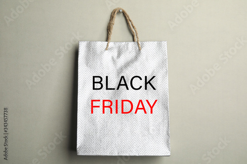 Shopping bag with text BLACK FRIDAY on grey background