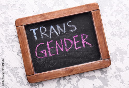 Chalkboard with text TRANS GENDER on light background photo