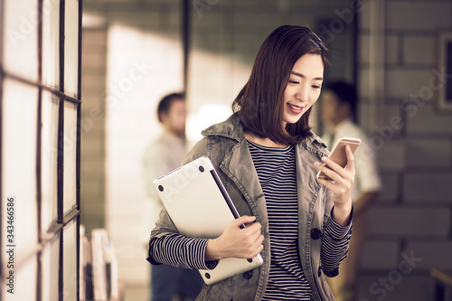 Photography young asian businesswoman checking message on cellphone