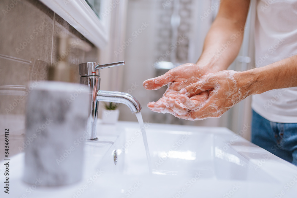 Close up of caucasian man washes his hands in the bathroom. COVID - 19 prevention Close up of caucasian man washes his hands in the bathroom. COVID - 19 prevention