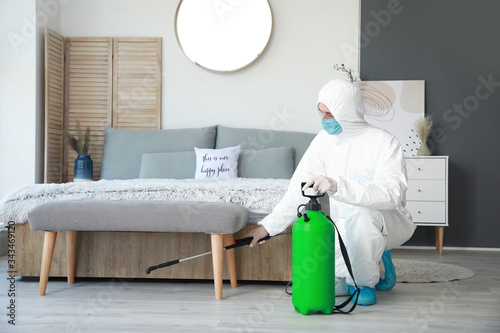 Worker in biohazard suit di...