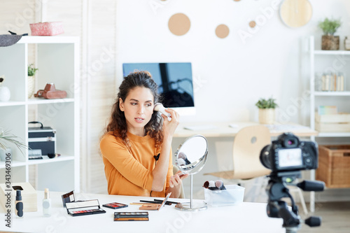 Young adult Caucasian woman doing casual make-up and recording process on camera