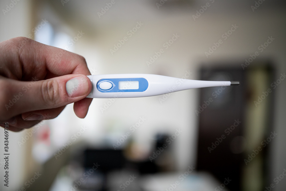 man holds a medical thermometer in his hand