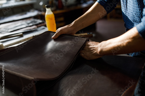 A leather craftsman works in a workshop. 