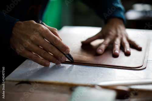 A leather craftsman works in a workshop. 