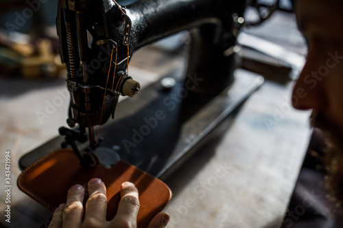 A leather craftsman works in a workshop. 
