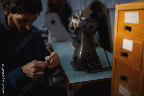 A leather craftsman works in a workshop. 