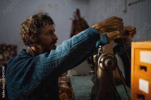A leather craftsman works in a workshop. 