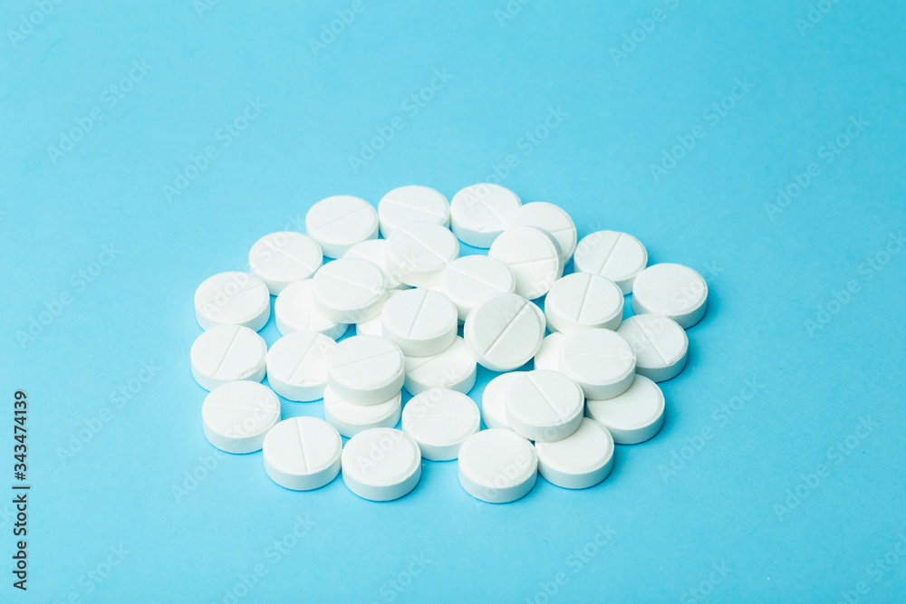 Pills background. Pills, drags and medecine concept. White tablets on a blue background
