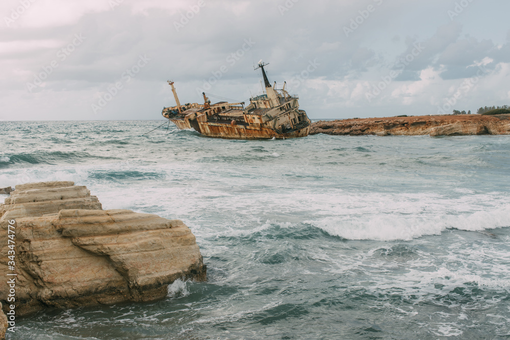 rusty ship in water of mediterranean sea against sky with clouds