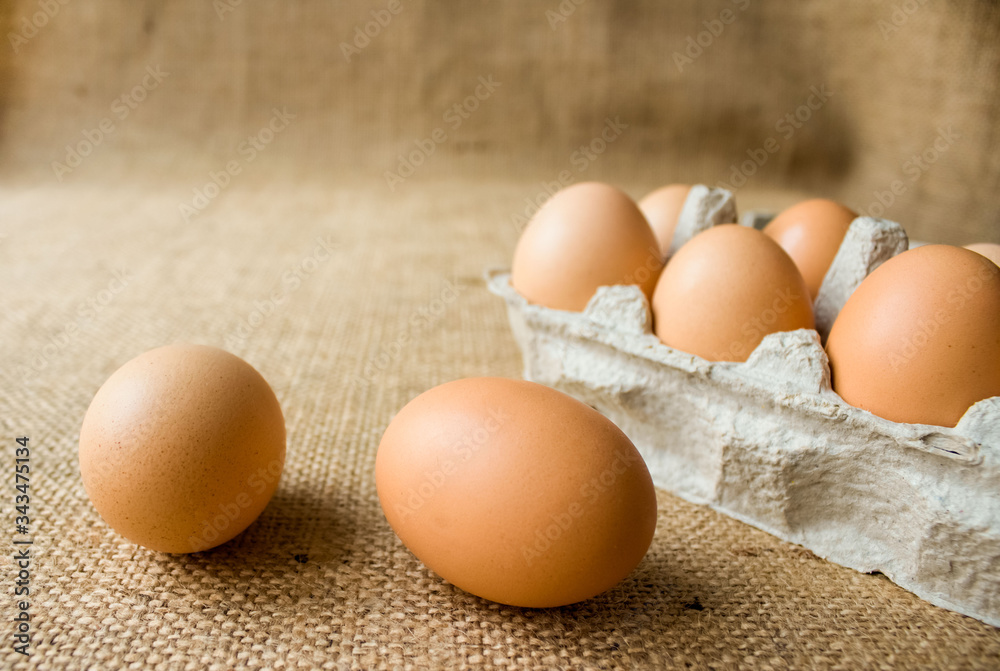 Close-up of fresh raw organic chicken eggs in egg box on natural fabric background from local farmer market with copyspace. Selective focus Close-up of fresh raw organic chicken eggs in egg box on natural fabric background from local farmer market with copyspace. Selective focus