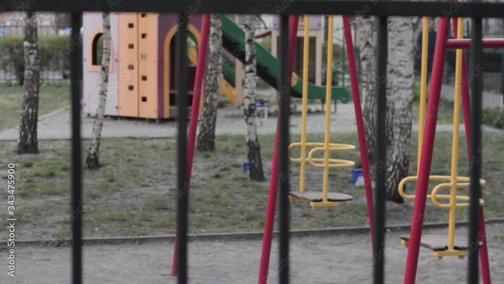 Empty children's playground behind the fence Empty children's playground behind the fence