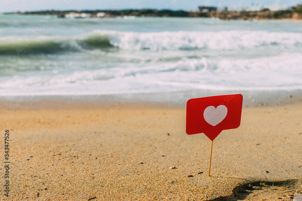 Fototapeta premium LIMASSOL, CYPRUS - MARCH 31, 2020: red heart on stick on sand near mediterranean sea