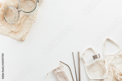 Zero waste concept. Textile eco bags, glass jars on white wooden background with copy space.