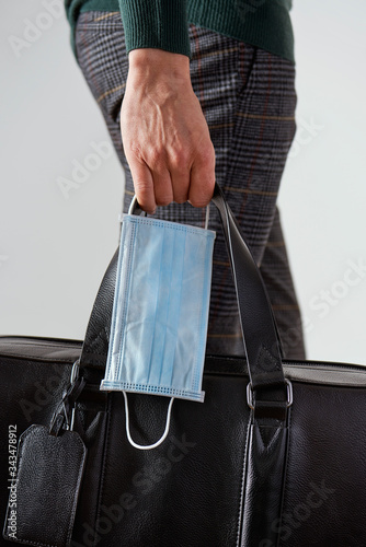 man with a suitcase and a surgical mask